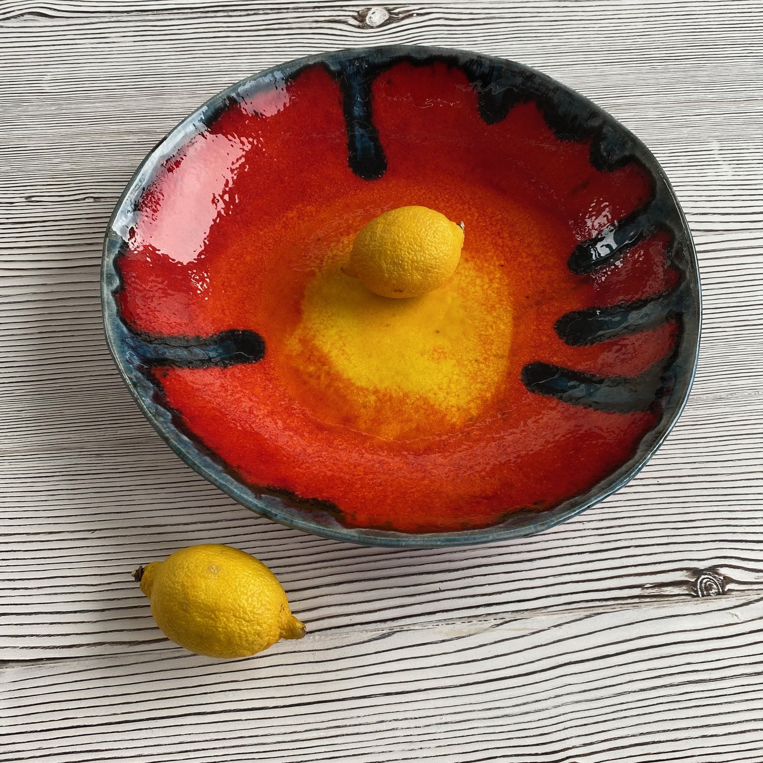 brightly coloured ceramic fruit bowl with a lemon to show scale