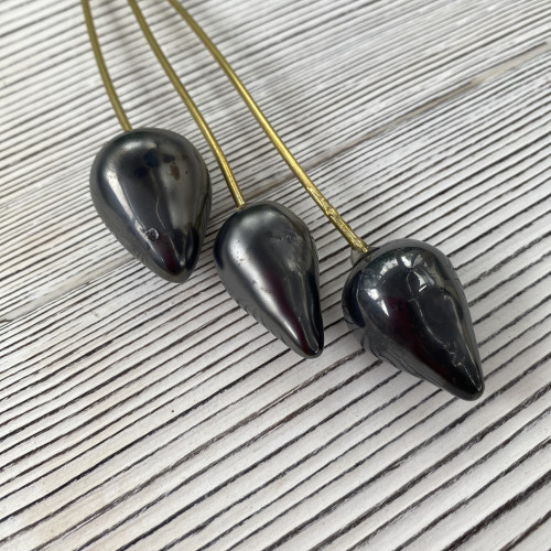 3 handmade ceramic black poppy seed buds for floral laying on their side with a wire stem arrangement