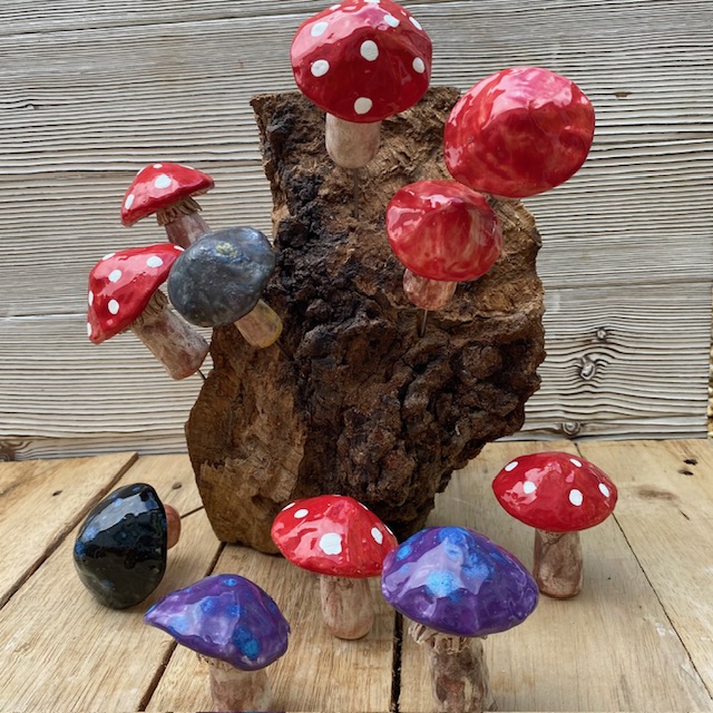 ceramic mushrooms displayed on a decorative piece of wood
