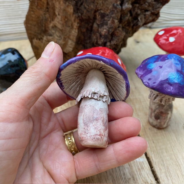 ceramic fungi being held in a hand to show the detail on the stem